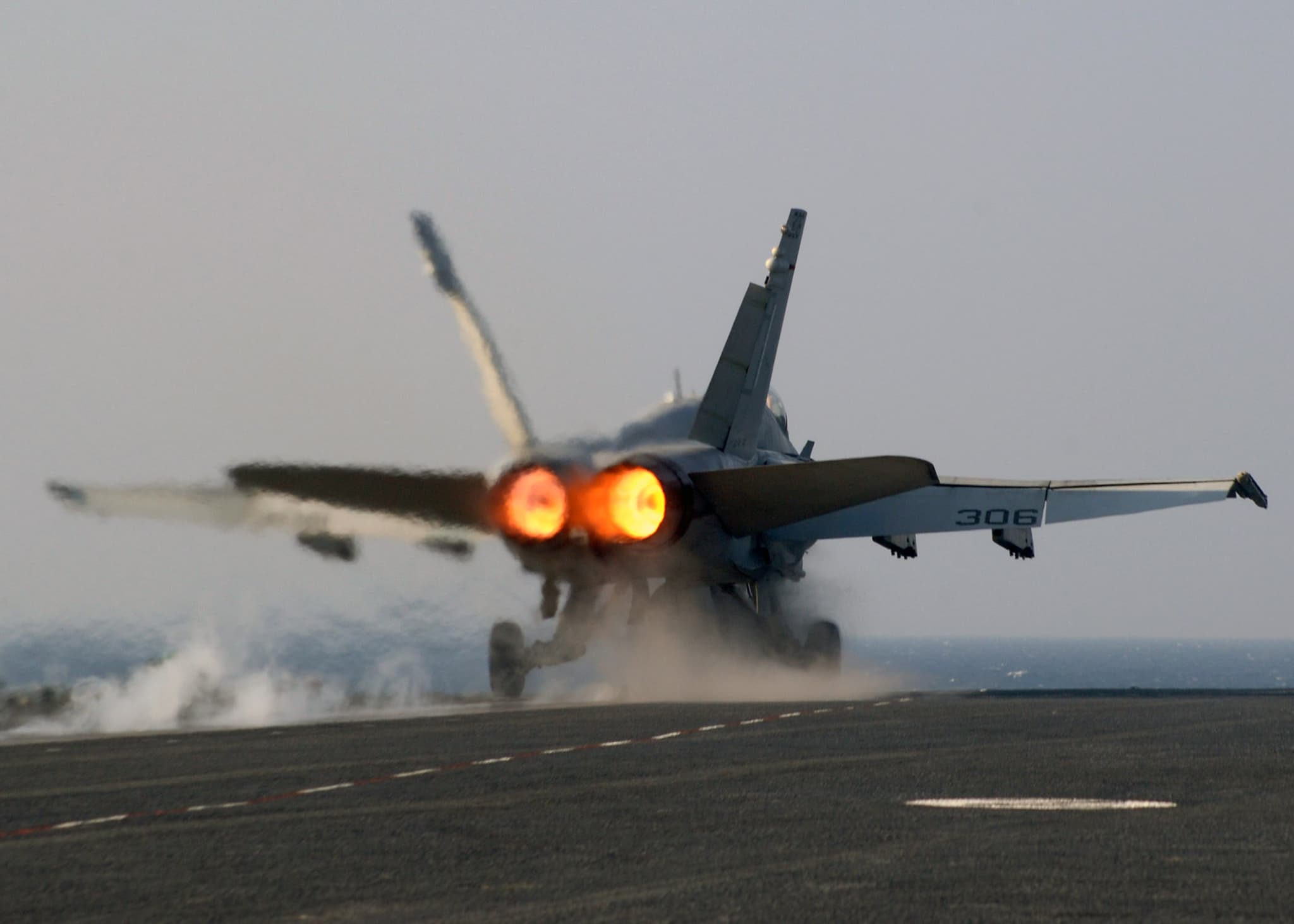 Fighter jet in afterburner showing the distinctive blue-orange flame plume from the engine nozzle