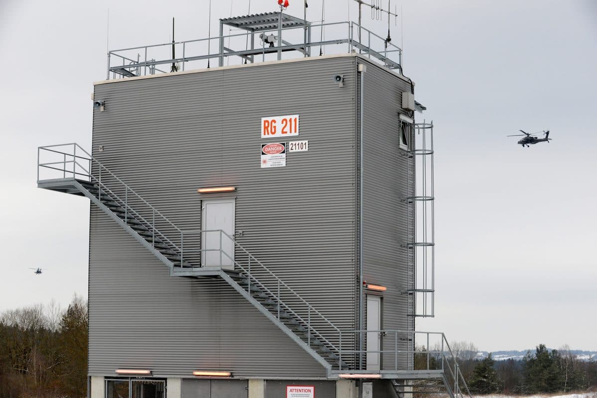 AH-64D Apache Longbow attack helicopter in flight during combat operations with Longbow radar dome visible above rotor