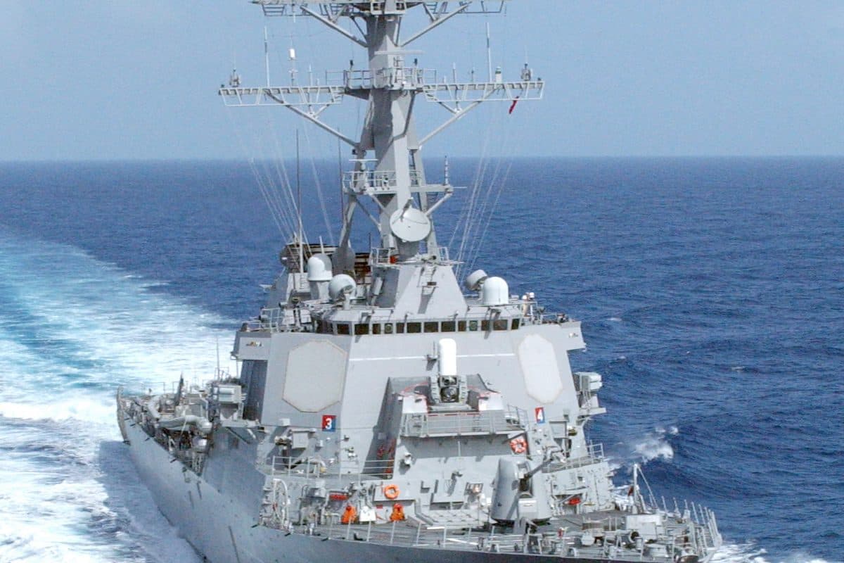 Arleigh Burke-class guided missile destroyer at sea showing its Aegis radar arrays and vertical launch system