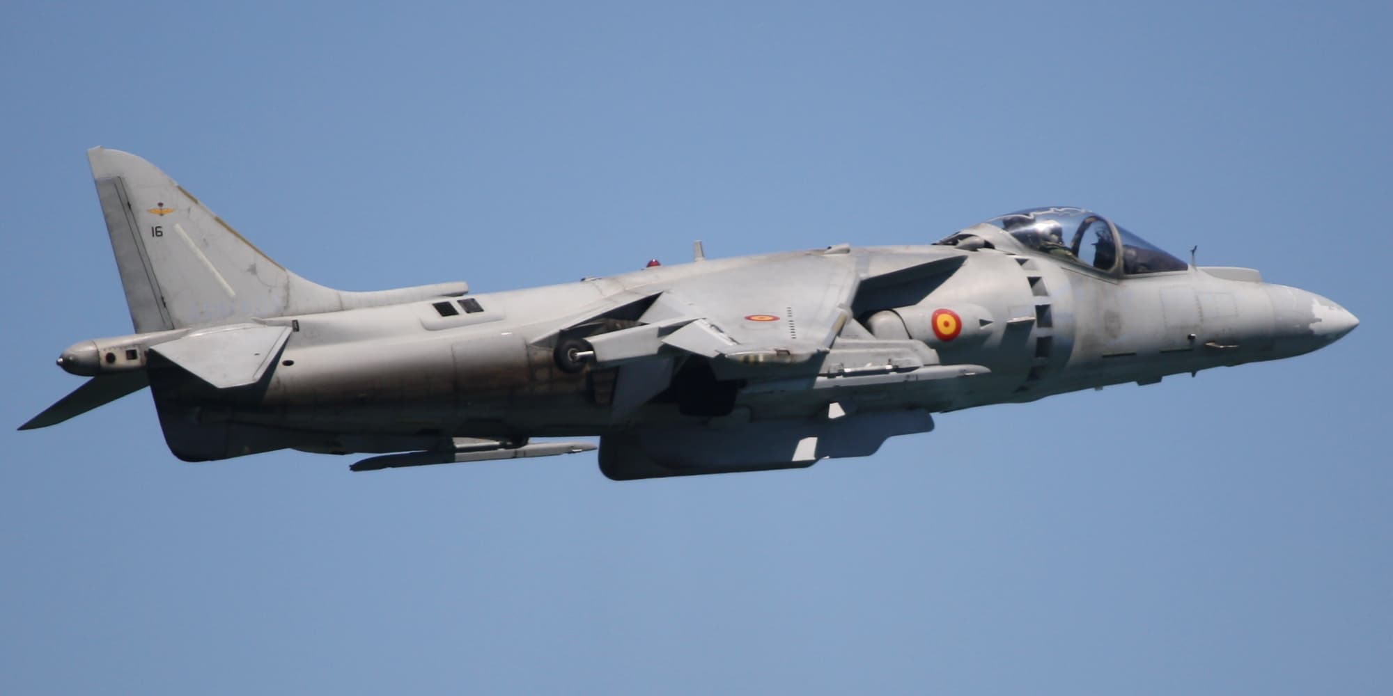 AV-8B Harrier II hovering near a Marine amphibious assault ship during flight operations