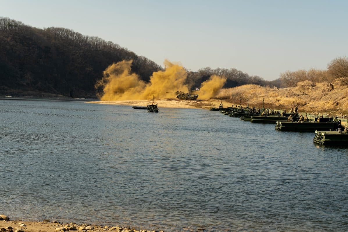 M1 Abrams tank positioned on an Improved Ribbon Bridge during a wet gap crossing test, with the floating bridge structure visible beneath the tank's tracks