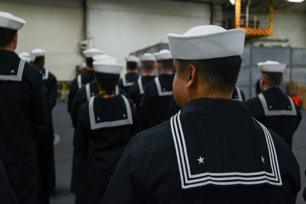 U.S. Navy sailors standing in formation during a dress uniform inspection aboard USS Nimitz
