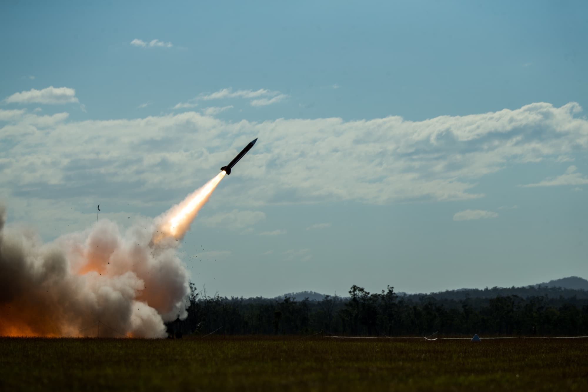 MIM-104 Patriot missile launcher in firing position with radar unit visible in background at a deployed air defense site