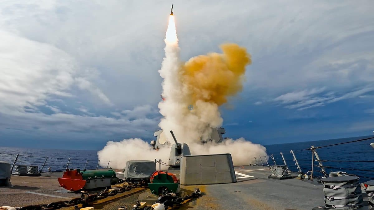 Sailors reload a Vertical Launch System cell aboard a US Navy destroyer at sea, showing the scale of missile logistics