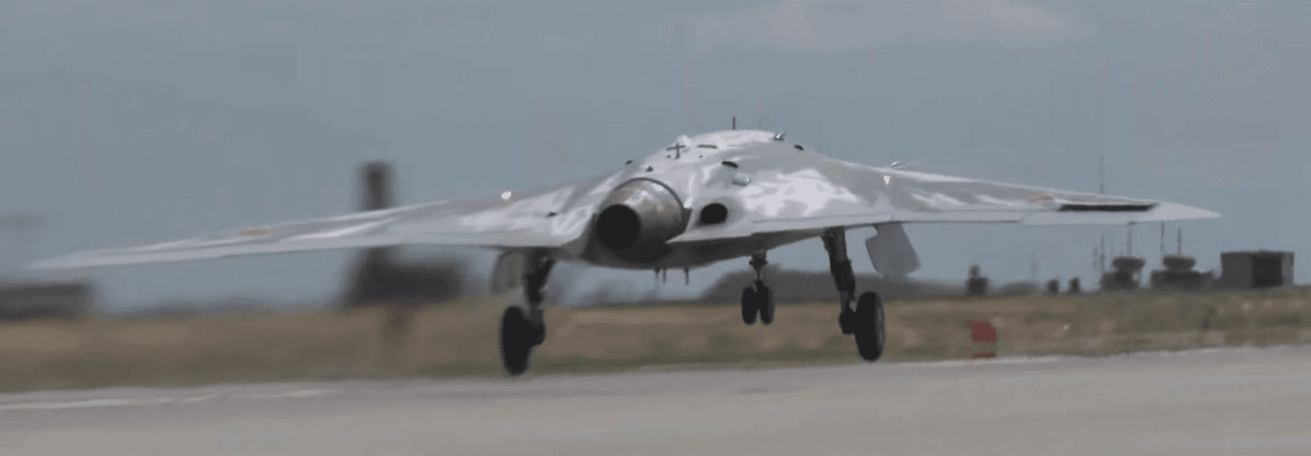 Sukhoi S-70 Okhotnik stealth combat drone in flight showing flying wing design