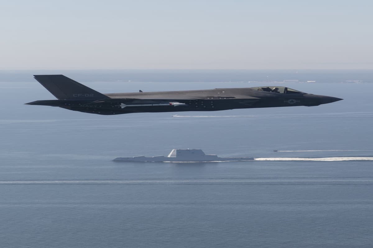 F-35 stealth strike fighter flying over USS Zumwalt DDG-1000 guided-missile destroyer