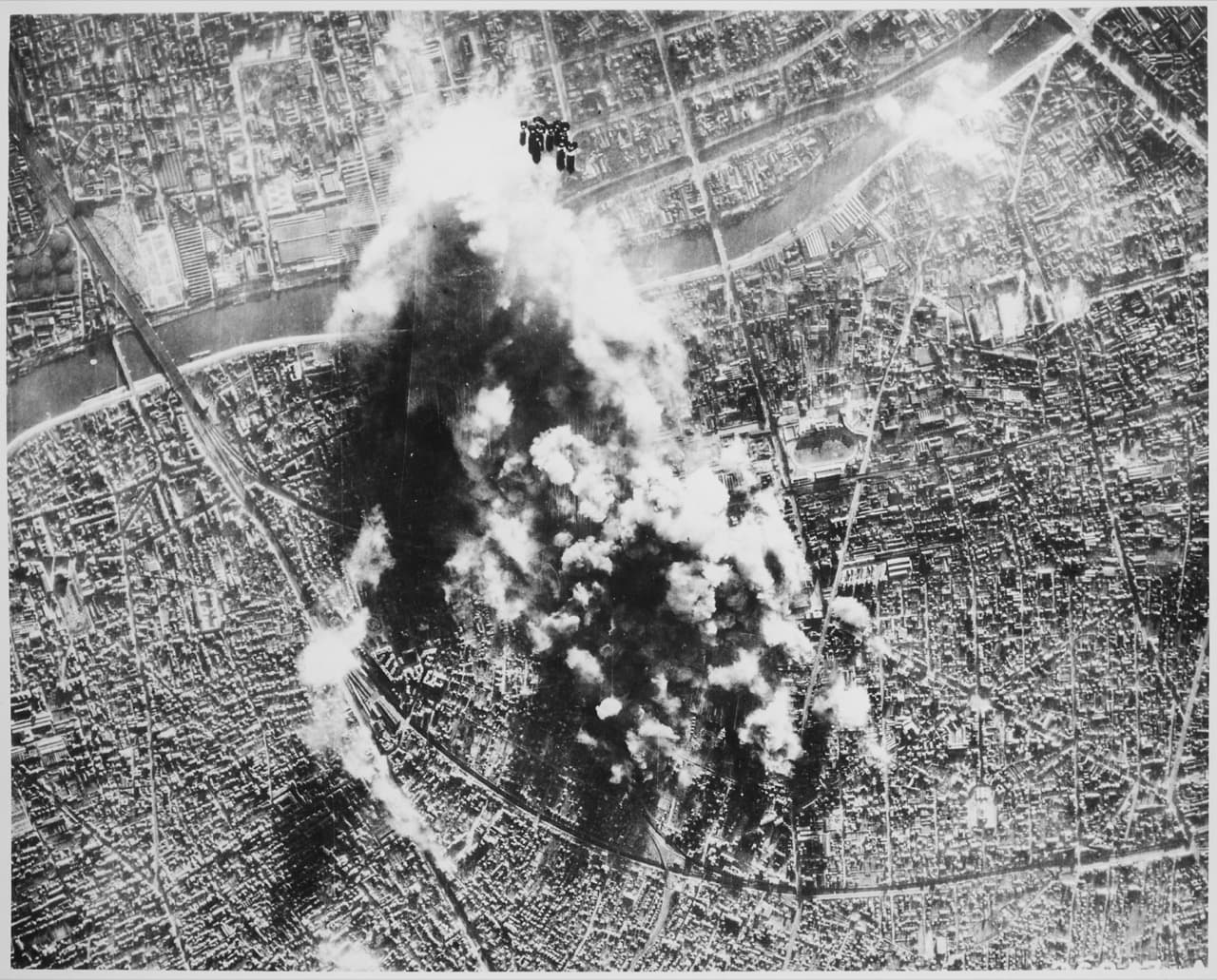 B-17 Flying Fortresses over a European city during a strategic bombing raid with bombs falling