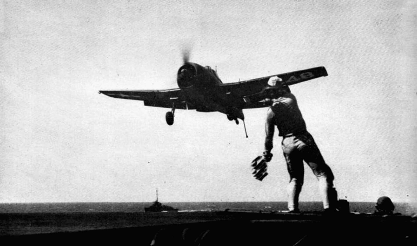 F6F-5 Hellcat landing aboard USS Tripoli with LSO guiding approach, 1945