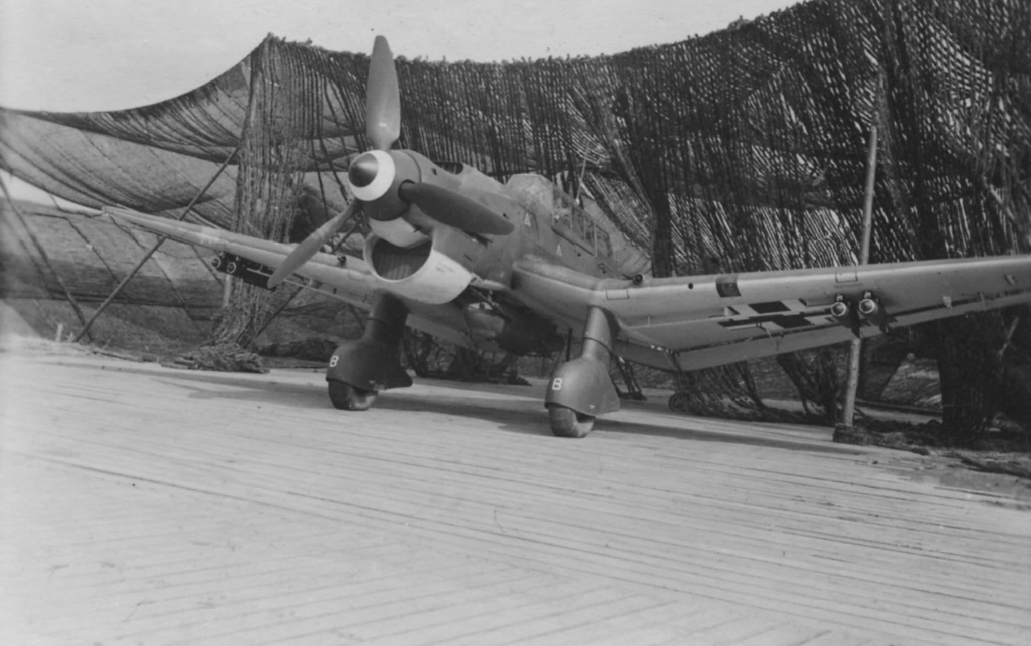 Bomb-laden Ju 87 Stuka at Schiphol under camouflage netting
