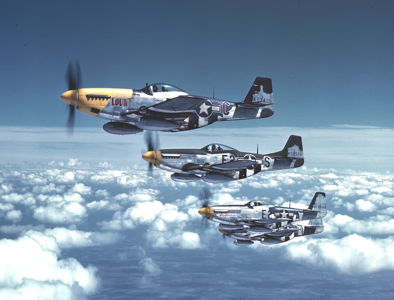Four P-51B Mustangs of the 361st Fighter Group in formation over RAF Bottisham, England, 1944