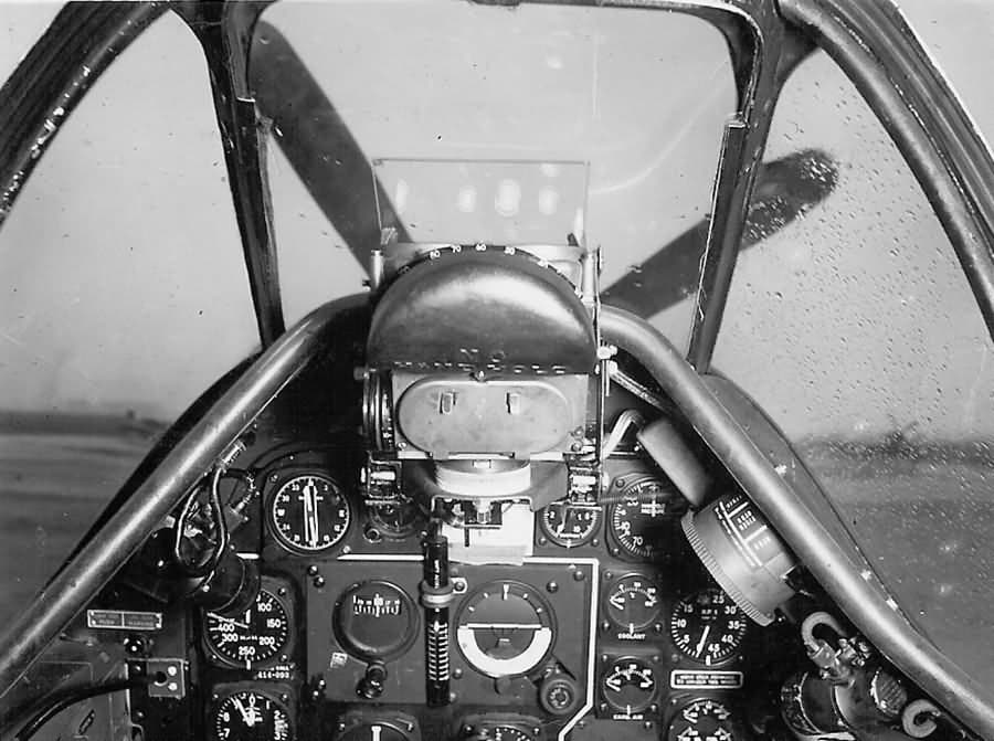 Interior view of a P-51D Mustang cockpit showing flight instruments, gunsight, and control stick