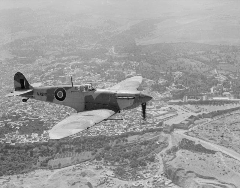 Supermarine Spitfire in flight over a town, showing the distinctive elliptical wing shape
