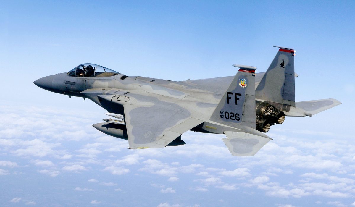 F-15 Eagle banking sharply against a blue sky