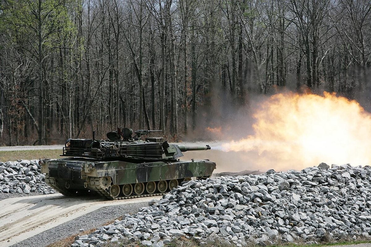 M1A2 Abrams main battle tank moving at speed across open terrain showing its low-profile turret and gas turbine exhaust