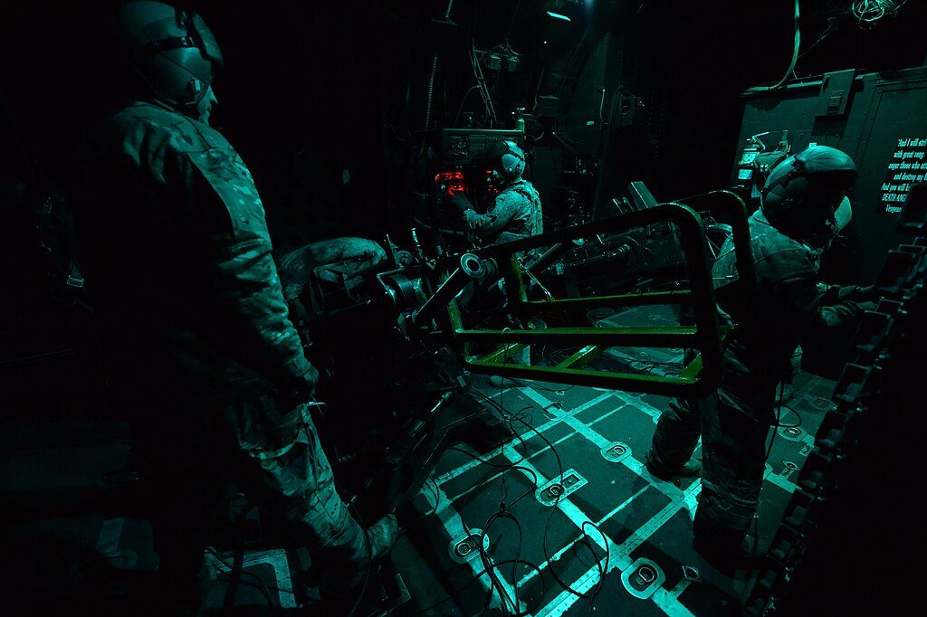 Crew operating weapons systems inside an AC-130 gunship during a combat sortie