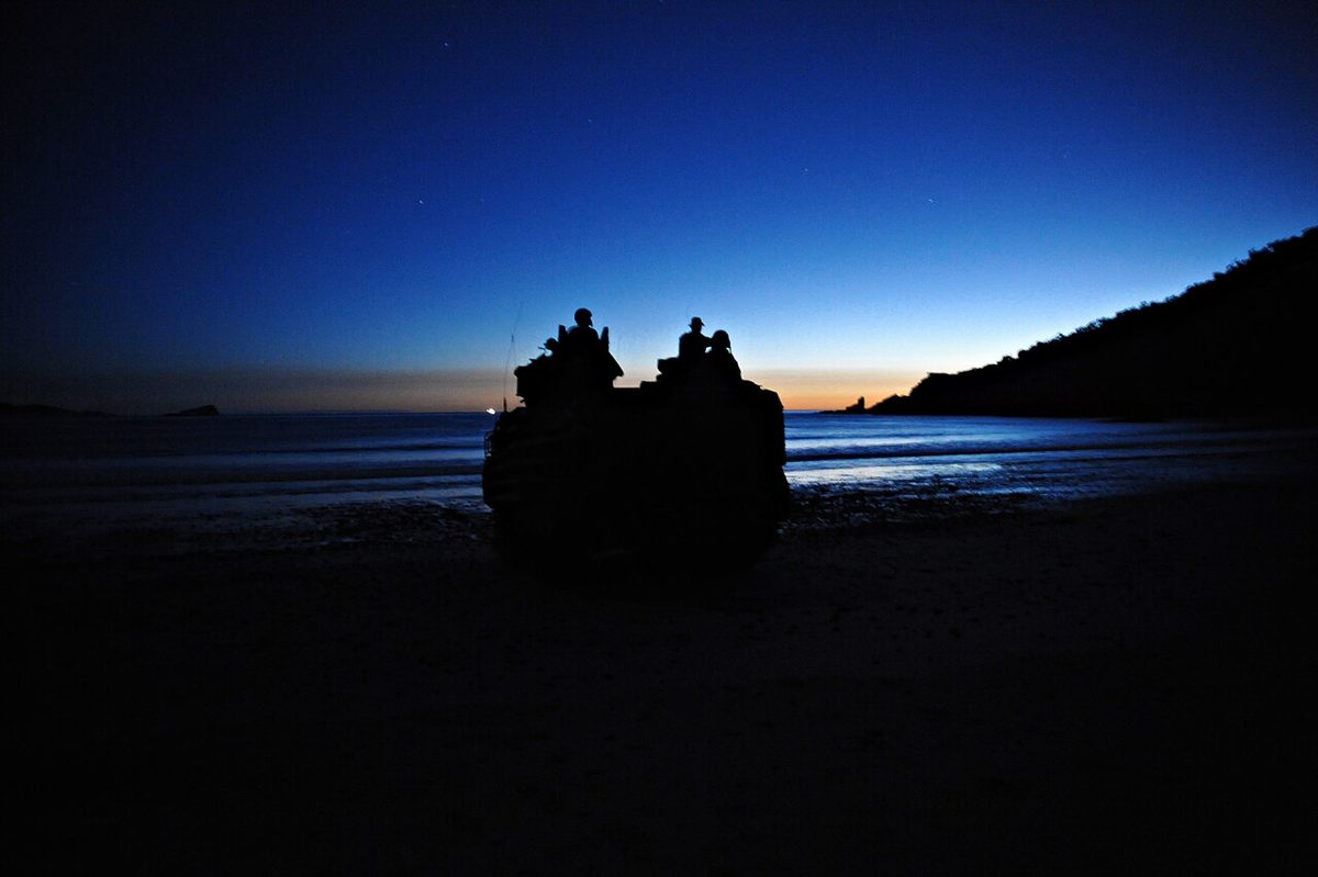 Marines standing on top of an AAV-7A1 amphibious assault vehicle