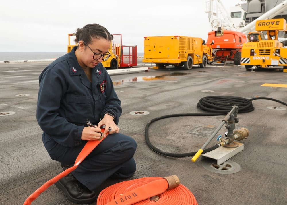 U.S. Air Force weapons technicians loading an AIM-120 AMRAAM missile onto a fighter aircraft's weapons rail