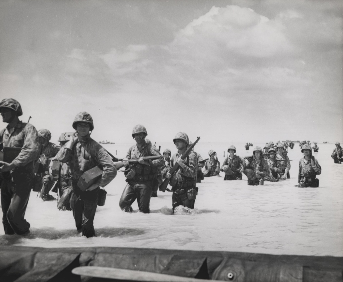 U.S. Marines advancing through debris and obstacles on Tarawa atoll, November 1943