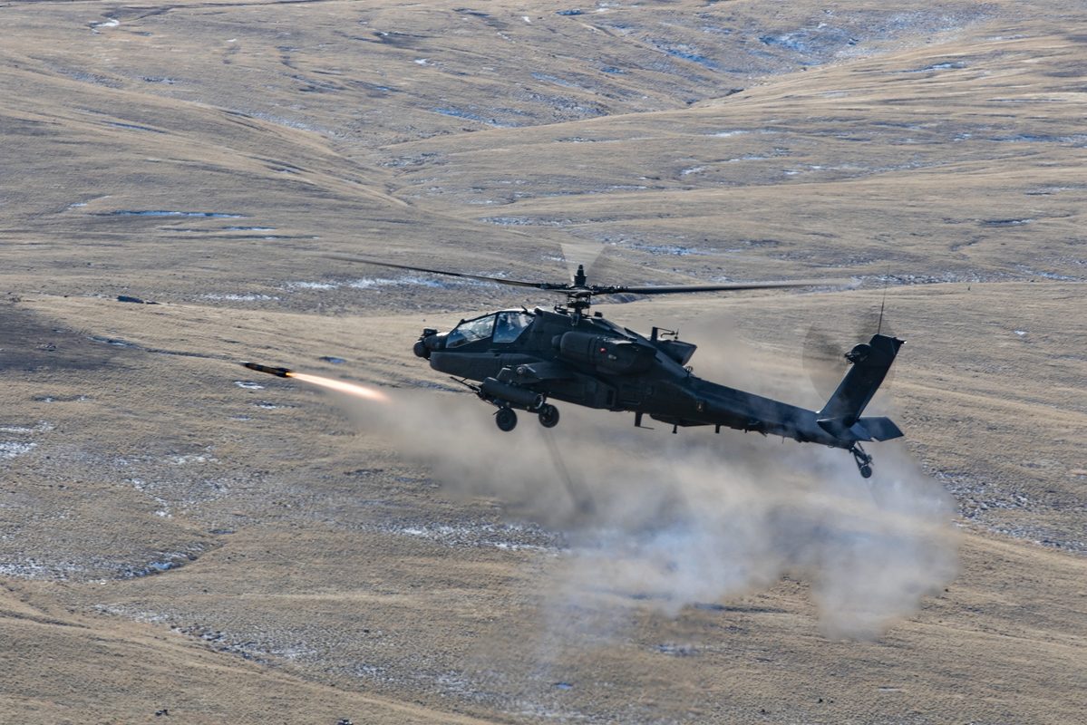 AH-64E Apache helicopter firing an AGM-114 Hellfire missile during live-fire training at Yakima Training Center