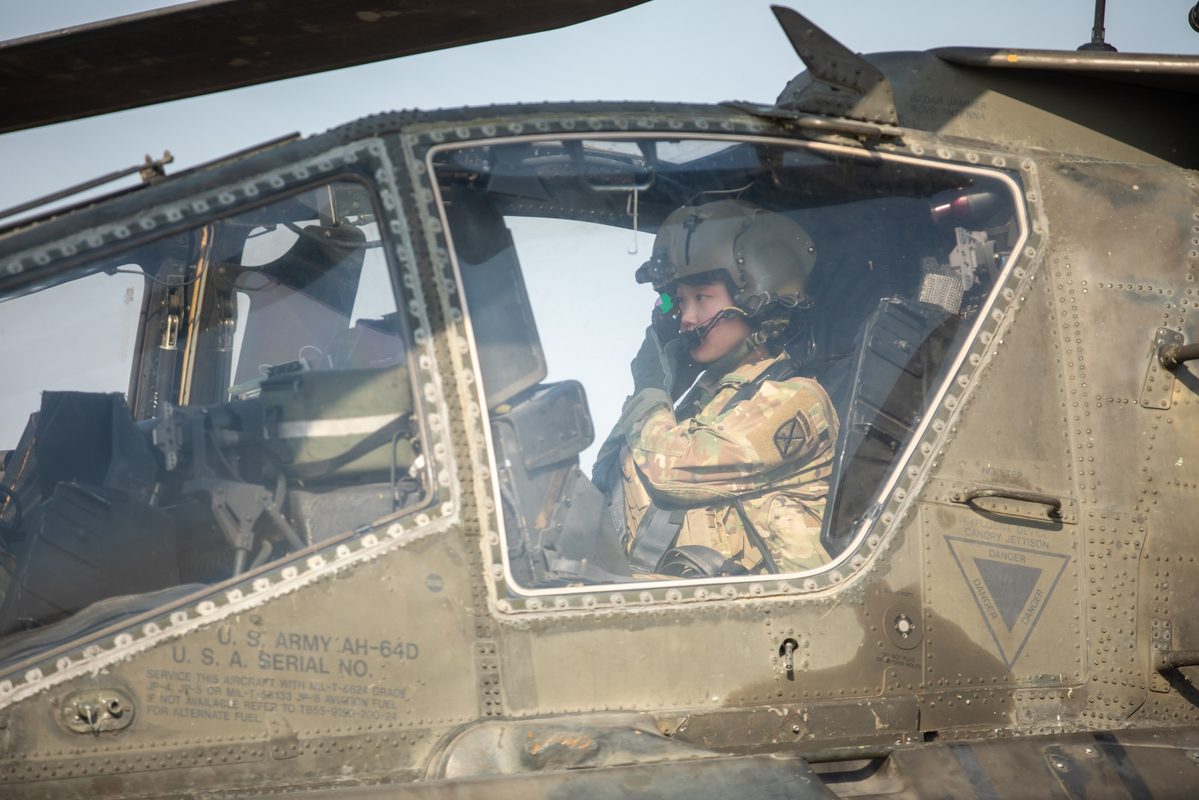 AH-64 Apache pilot adjusting the IHADSS helmet-mounted display system in the cockpit during operations in Iraq