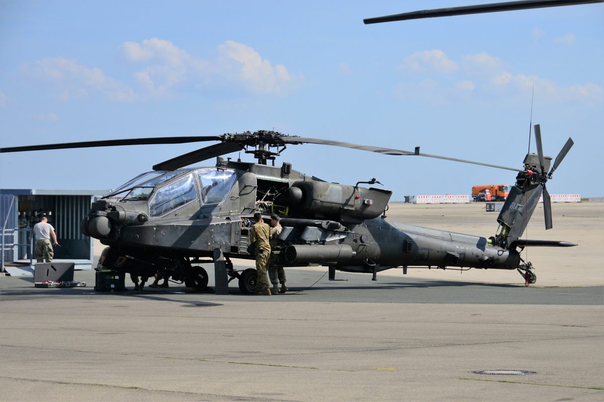AH-64D Apache Longbow helicopter in flight showing weapons pylons loaded with Hellfire missiles and rocket pods