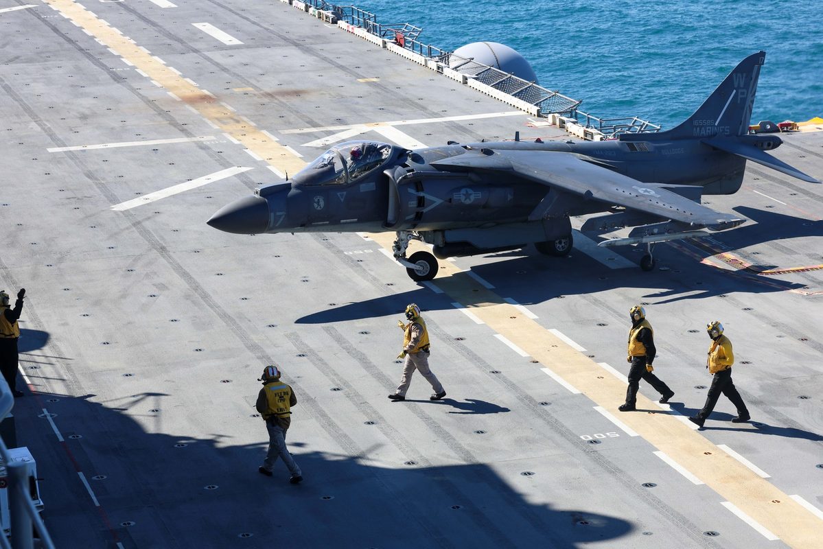 Multiple AV-8B Harrier II aircraft on the flight deck of a Marine amphibious assault ship