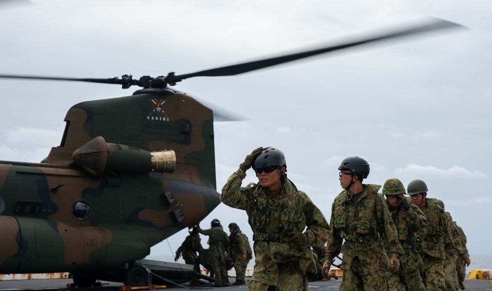 Marines loading equipment aboard a CH-47 Chinook helicopter during joint training exercises