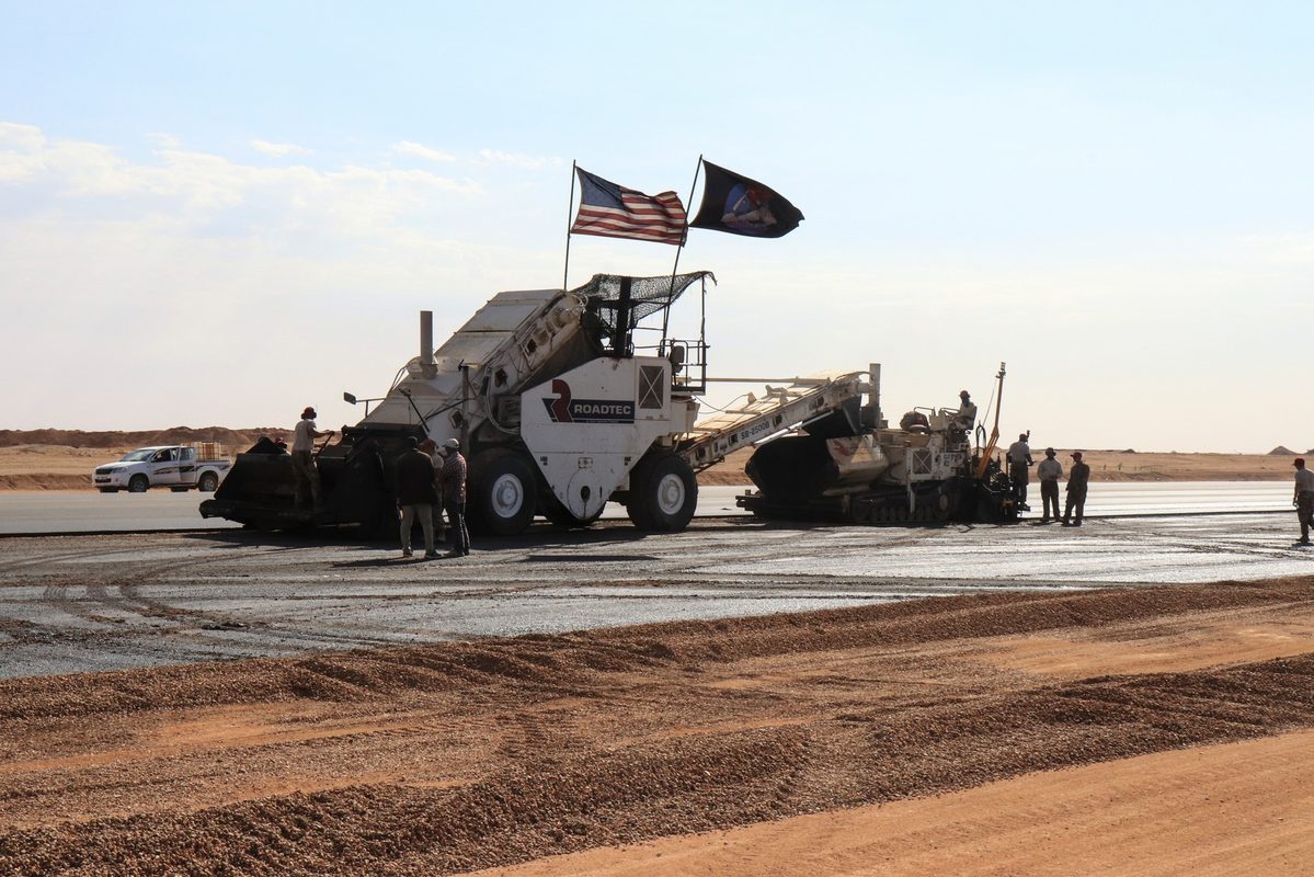 Military construction personnel working on a flight line project at a forward operating base