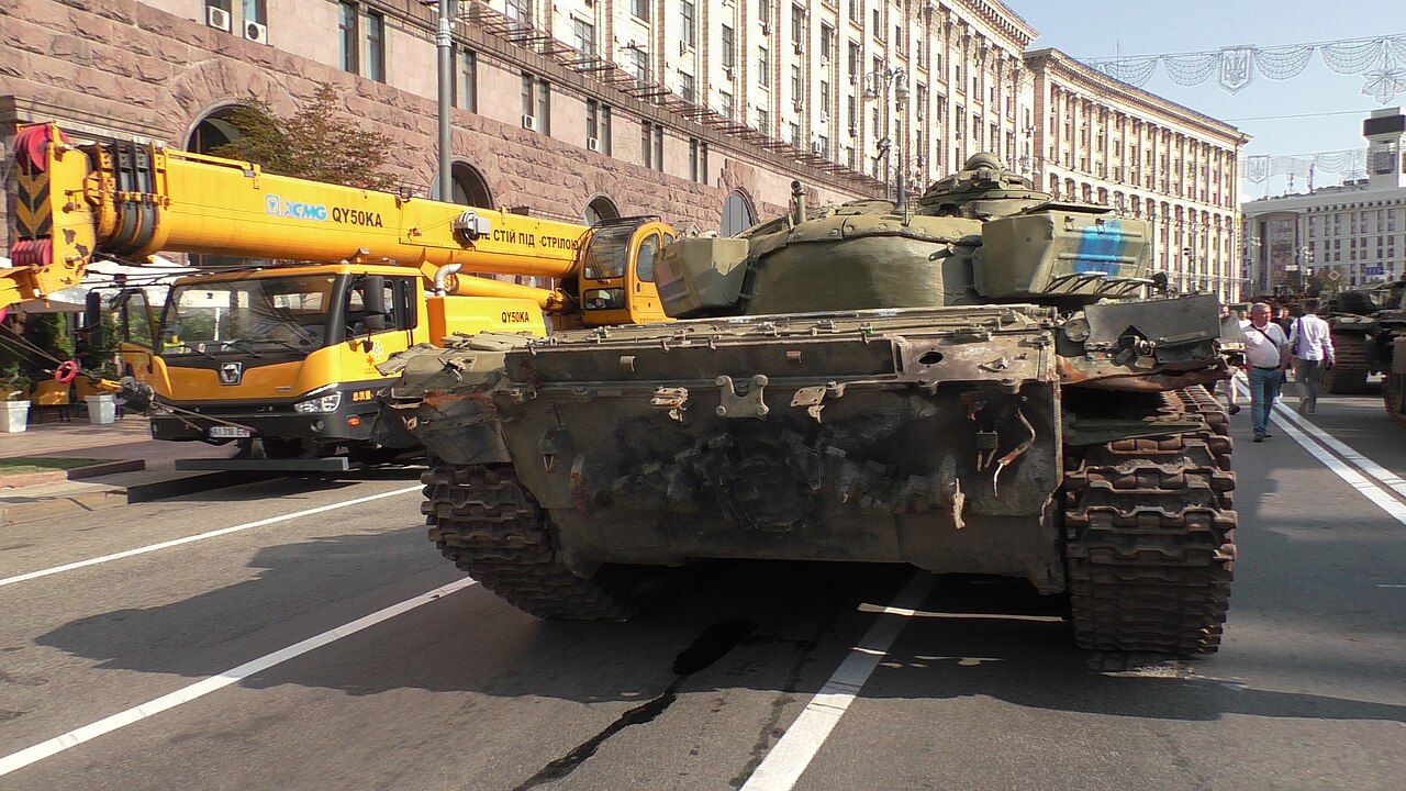 A destroyed Russian tank with visible damage from a top-attack drone strike in Ukraine