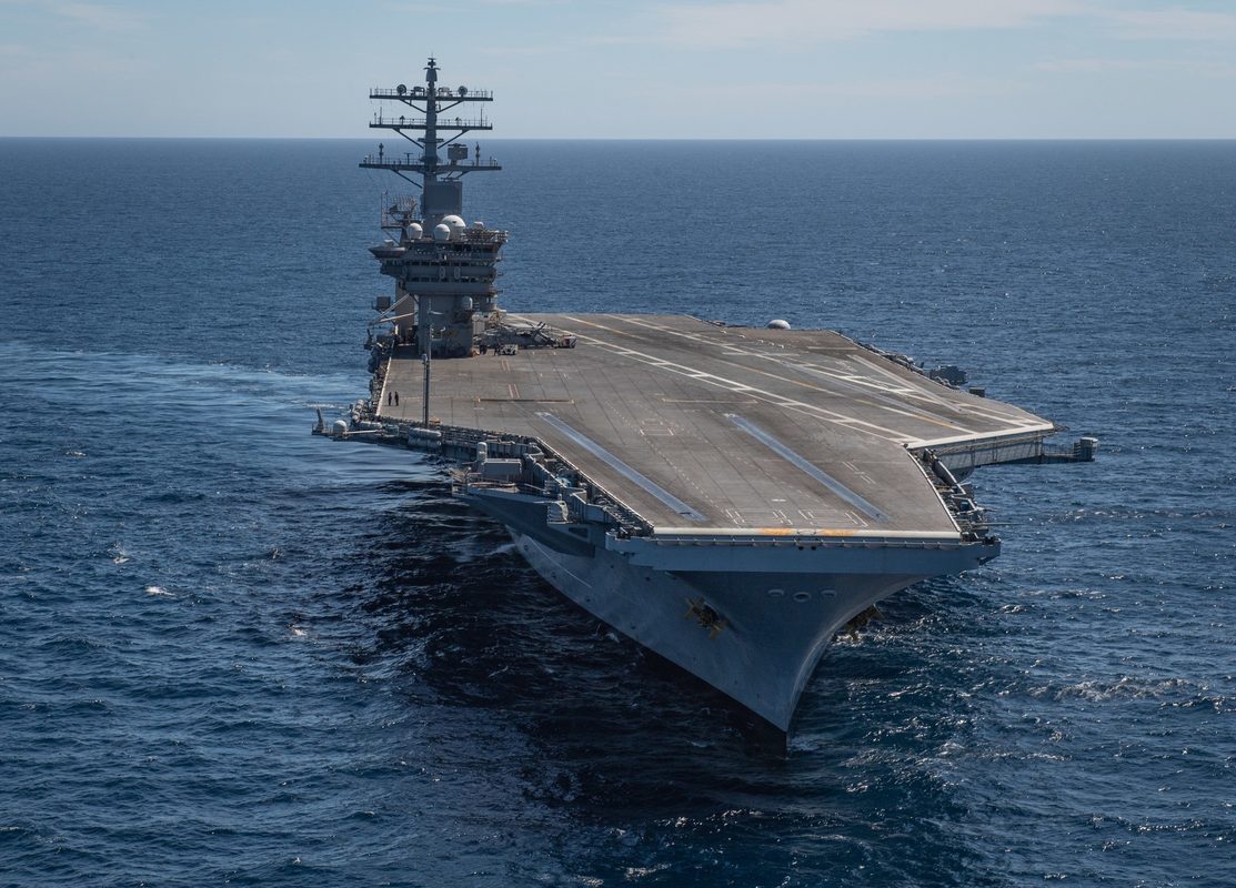 US Navy aircraft carrier underway in the Pacific Ocean, aerial view showing full flight deck
