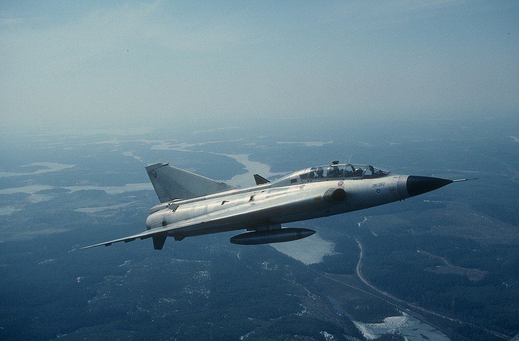 Two-seat Saab Draken variant in flight over Swedish landscape