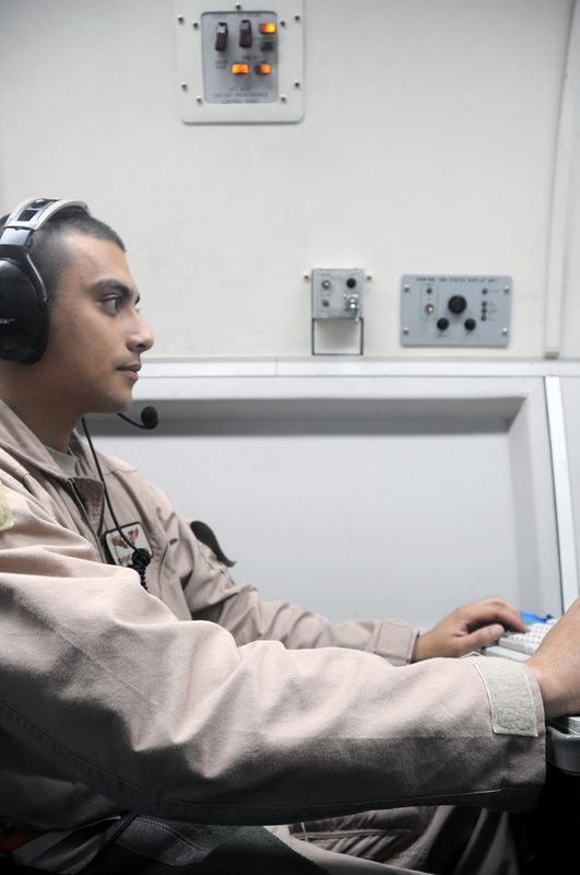 Interior of an E-3 AWACS aircraft showing radar operator consoles