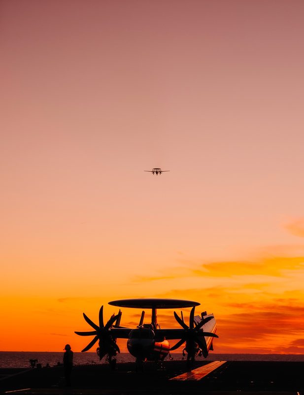 E-2D Advanced Hawkeye airborne early warning aircraft in flight, with its distinctive circular radar dome mounted above the fuselage