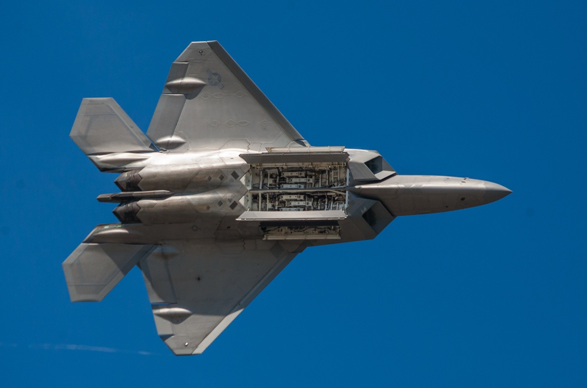 F-22 Raptor with internal weapons bay doors open, revealing AIM-120 AMRAAM missiles mounted on launch rails