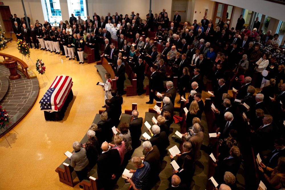 Weapons loading crew preparing ordnance for an F-22 Raptor on the flight line, with precision-guided munitions visible on a loading cart