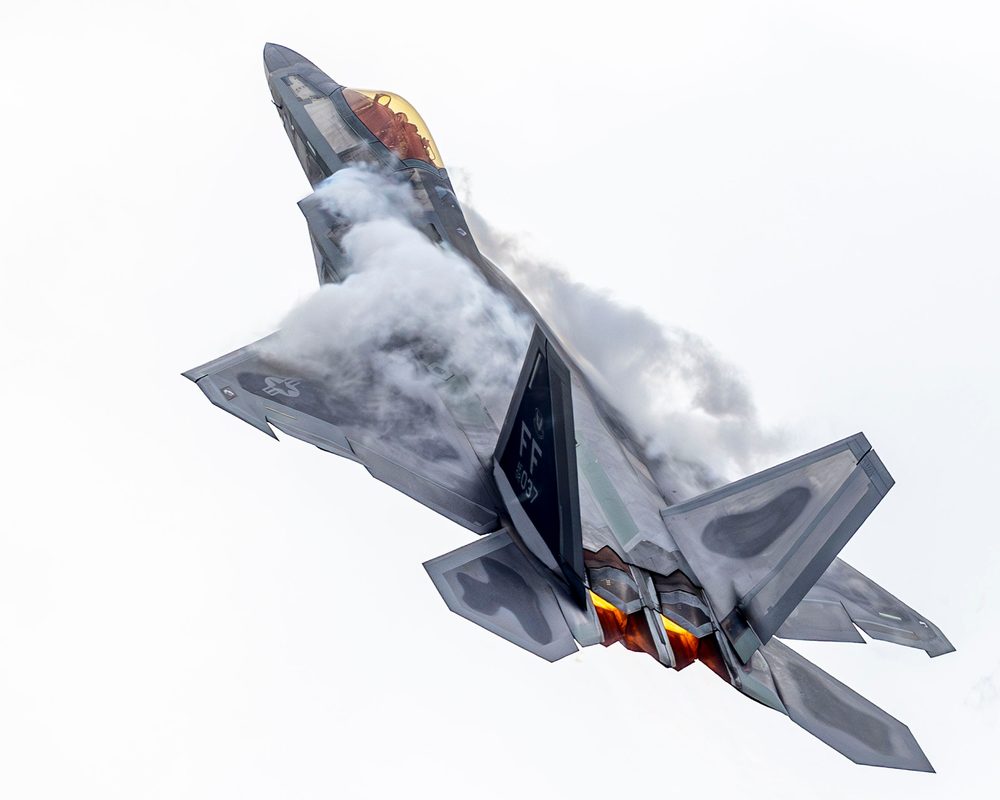 F-22 Raptor performing a high-angle-of-attack maneuver at a New York air show, demonstrating thrust-vectoring agility