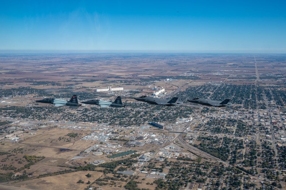 Two F-35 Lightning II fighters flying in formation over Vance Air Force Base with two T-38 Talons