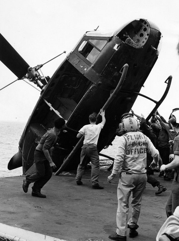 A South Vietnamese UH-1 Huey helicopter being pushed overboard from USS Okinawa during Operation Frequent Wind