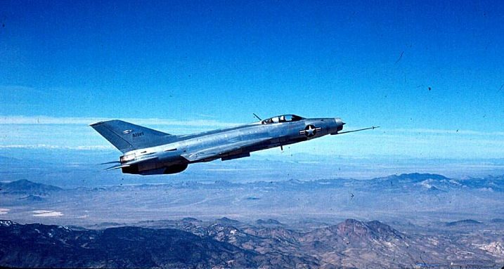 MiG-21 Fishbed in flight over desert mountains showing its delta wing and nose intake