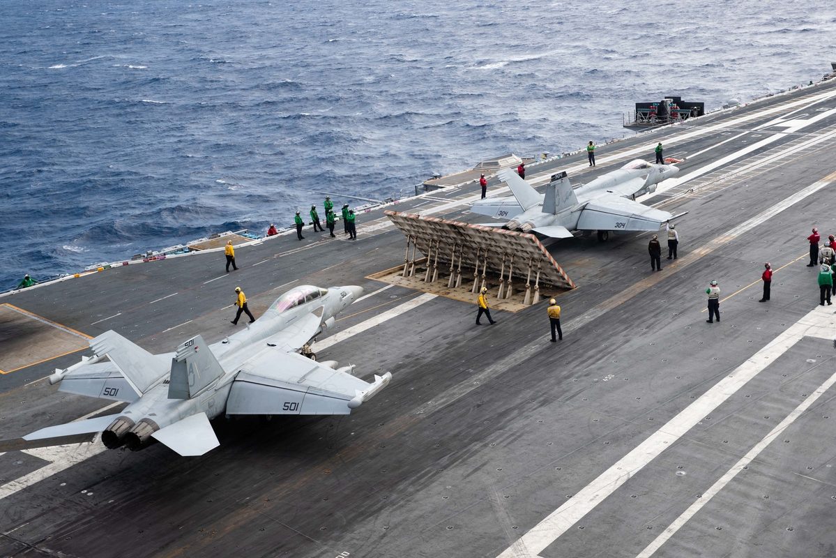 Fighter jets positioned on EMALS catapults on the flight deck of USS Gerald R. Ford, preparing for launch operations