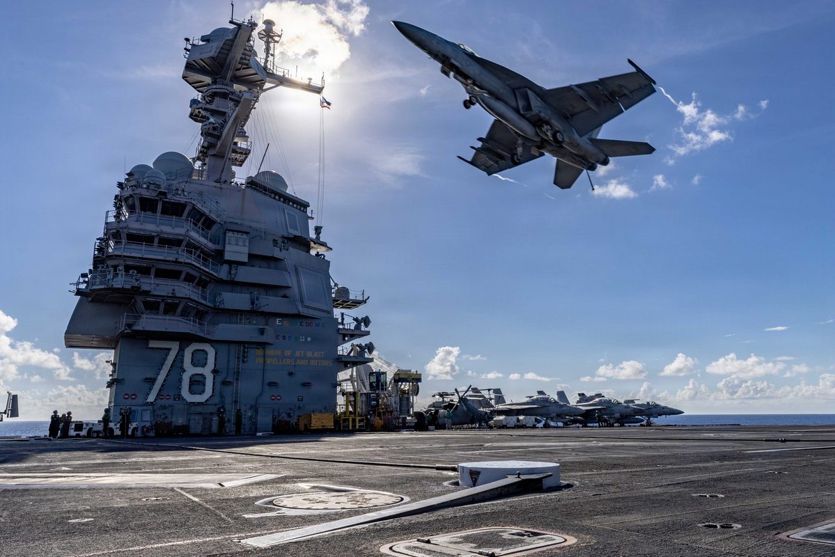 F/A-18E Super Hornet flying over the flight deck of USS Gerald R. Ford during flight operations in the Atlantic Ocean