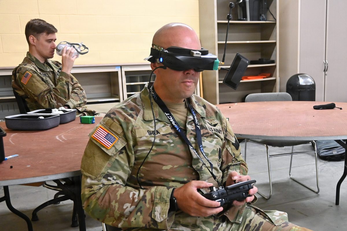 Soldier operating an FPV drone wearing goggles and using a controller for drone piloting