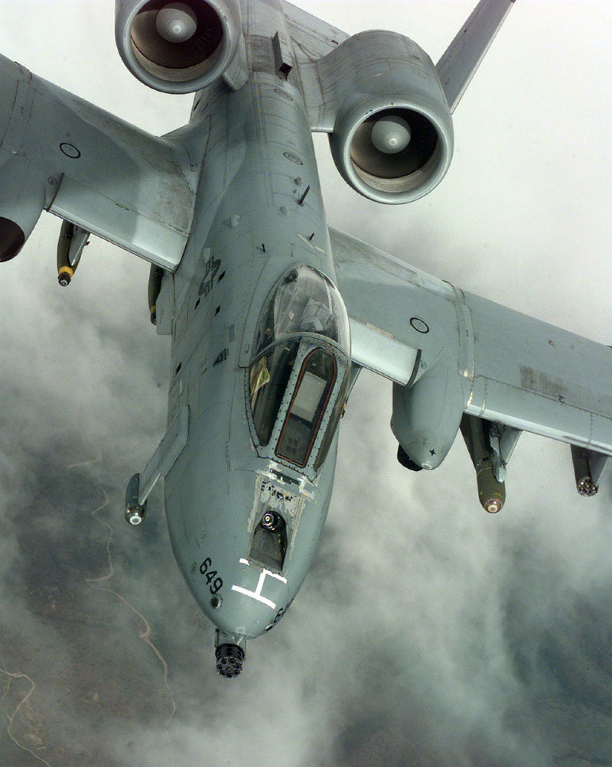 A-10 Thunderbolt II conducting a strafing run with visible gun smoke