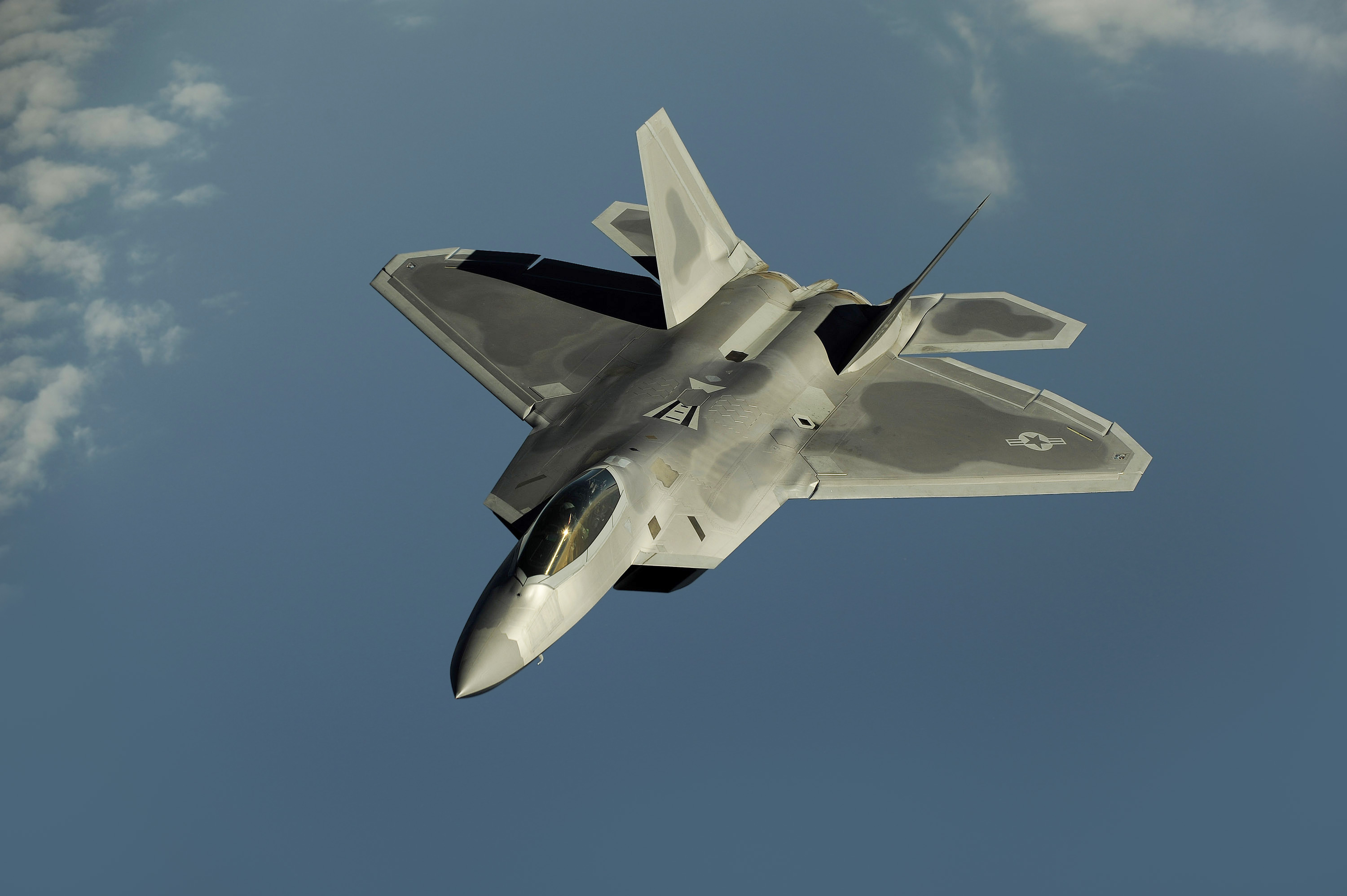F-22 Raptor in flight showing its compact stealth design and twin canted vertical tails