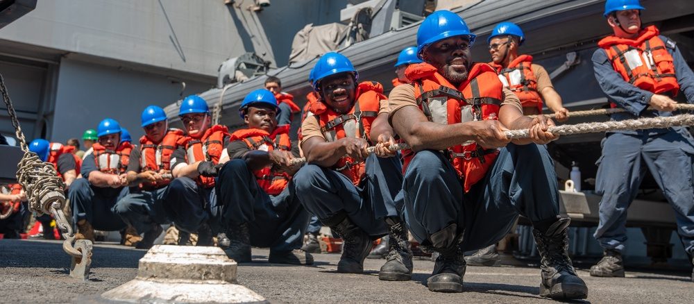 U.S. Navy sailors conduct an underway replenishment at sea between warships