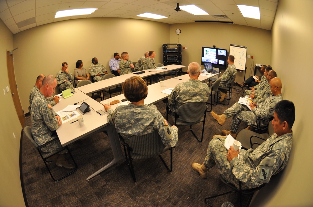 Military tactical planning session with maps and displays