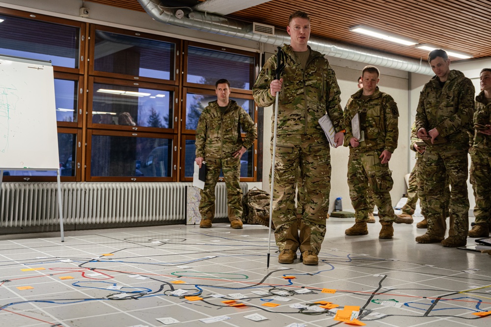 Military personnel during a tactical planning rehearsal briefing