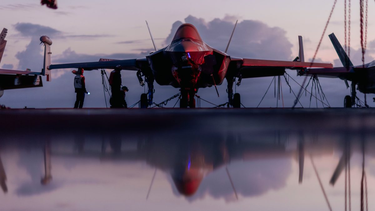 Sailors conducting maintenance on an F-35C Lightning II aboard the aircraft carrier USS George Washington in the Pacific Ocean