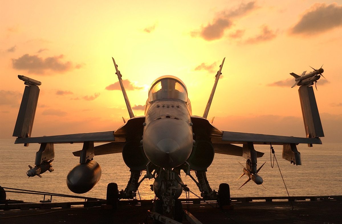 F/A-18 Super Hornet on carrier flight deck with weapons loaded for combat mission