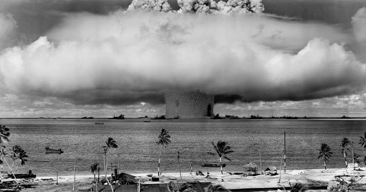 The Baker nuclear test explosion at Bikini Atoll during Operation Crossroads in 1946, with a massive water column rising above the lagoon and target ships